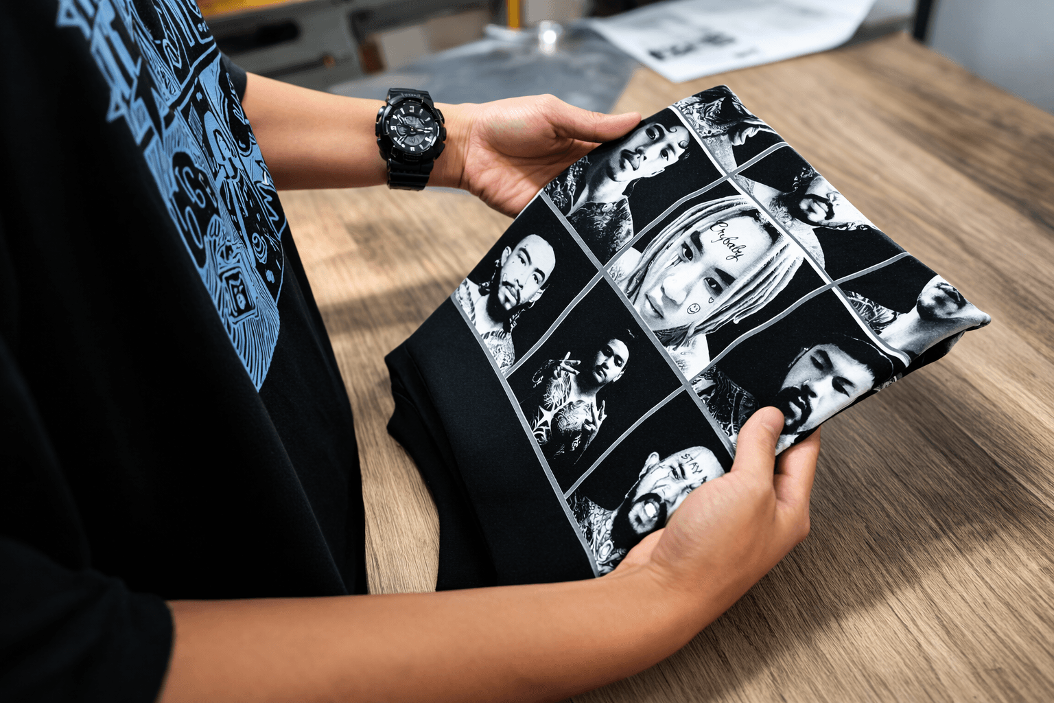 พนักงานกำลังตรวจสอบคุณภาพเสื้อยืดที่สกรีนเสร็จแล้ว - Anajak T-Shirt