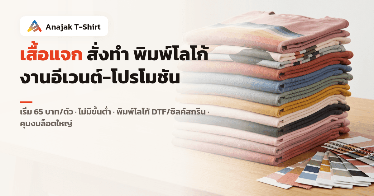 เสื้อยืดเปล่าหลากสีพับเรียงซ้อนเป็นกองสูงบนโต๊ะไม้ ข้างการ์ดตัวอย่างสีผ้า สื่อถึงเสื้อแจกสั่งทำจำนวนมากเลือกสีได้หลากหลาย