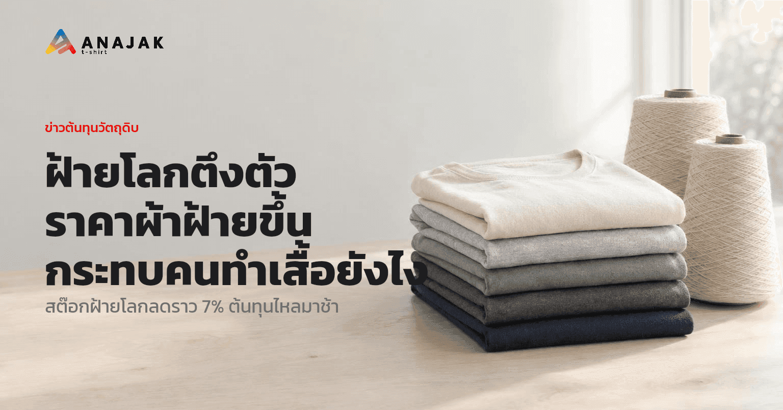 เสื้อยืดคอตตอนสีพื้นพับซ้อนเป็นตั้งบนโต๊ะไม้ มีกรวยด้ายฝ้ายสีธรรมชาติวางอยู่ข้างๆ สื่อถึงต้นทุนผ้าฝ้ายของคนทำเสื้อ